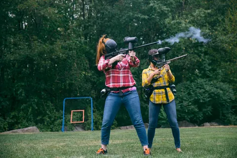 Two actors firing paintball guns on set