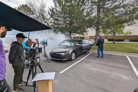 Smoke, a car and the crew in a parking lot