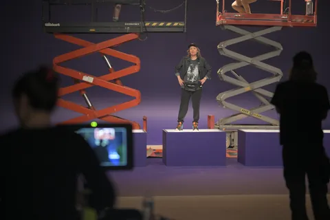 Two scissor lifts and an actor on the purple DocuSign stage